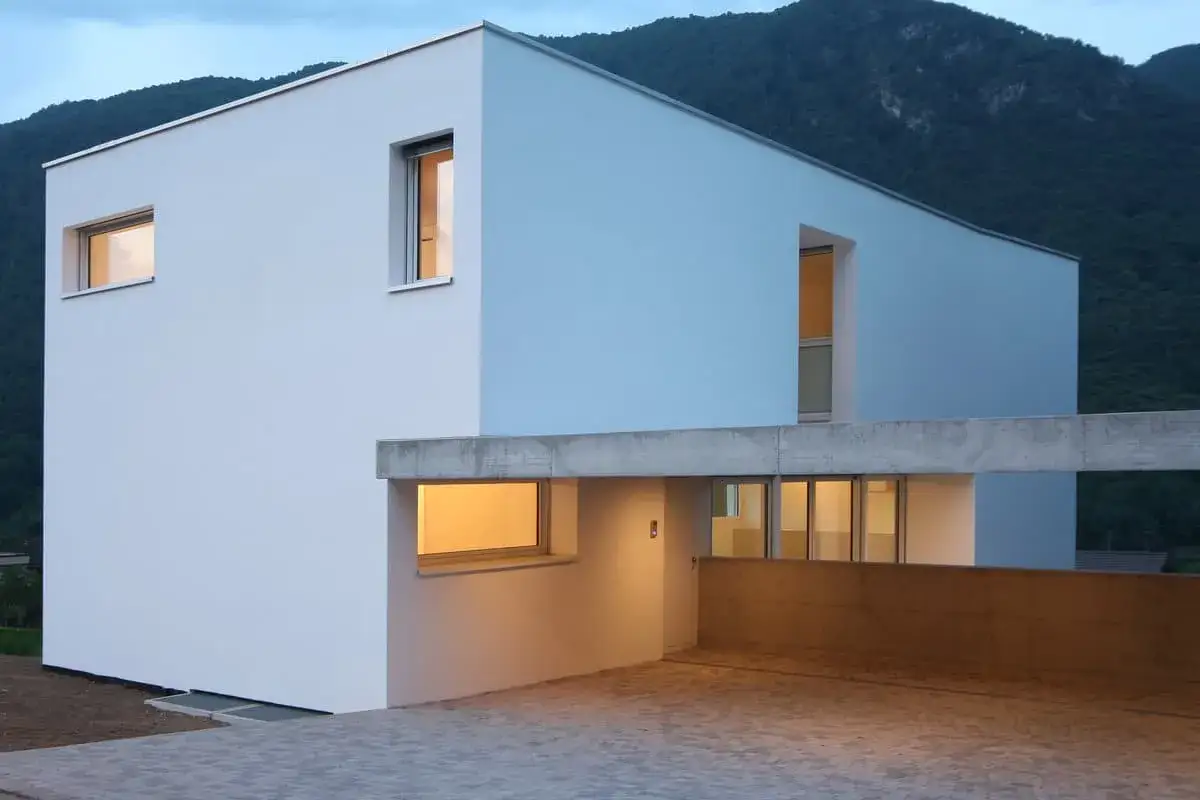 Maison moderne aux murs blancs et bleus, avec des fenêtres lumineuses. Idéal pour estimer le prix crépi maison 200m2.